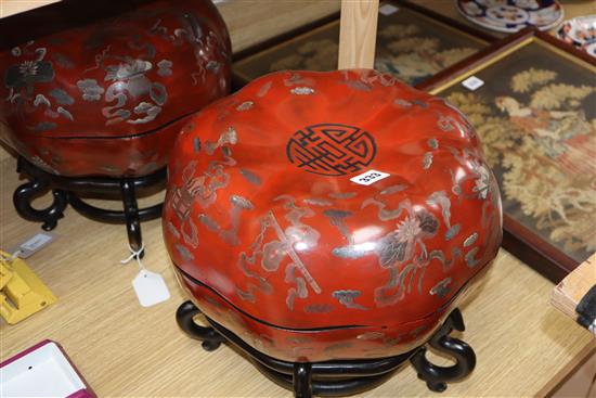A pair of Chinese red lacquer melon form lidded boxes, on hardwood stands, height 30cm